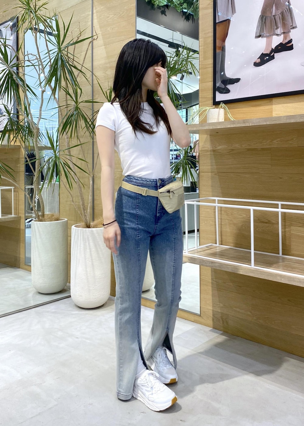 ブルー系のデニムパンツ、ホワイト系のスニーカー、ホワイト系のTシャツ/カットソーを着用したレディースの夏コーディネートの6枚目の写真