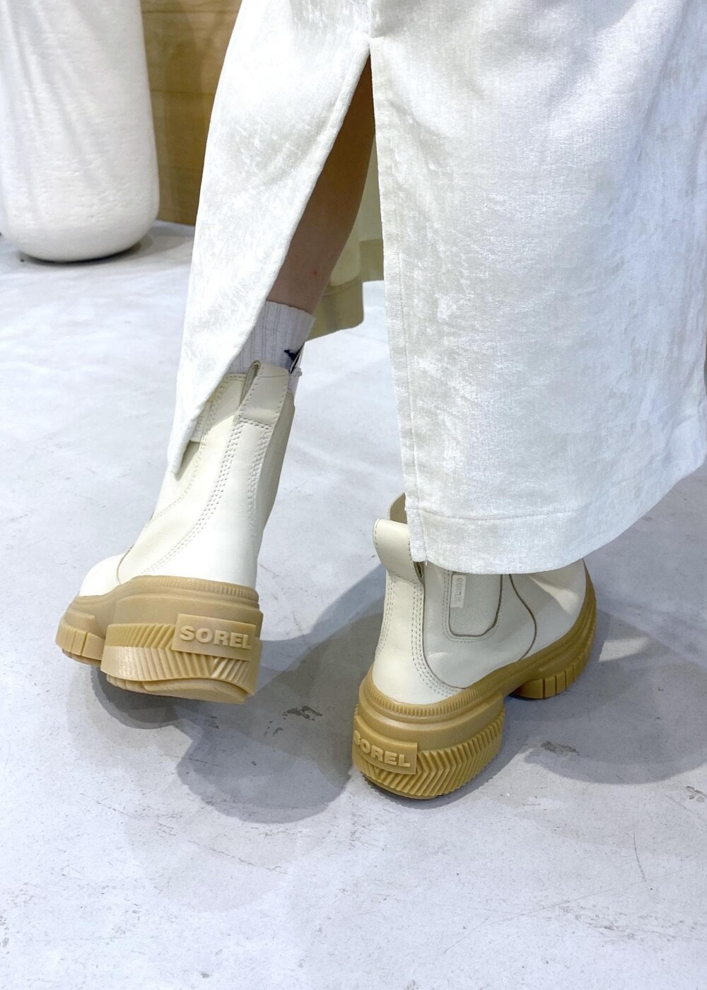 ベージュ系のダウンジャケット/コート、ホワイト系のブーツ、ホワイト系のスカートを着用したレディースの冬コーディネートの10枚目の写真