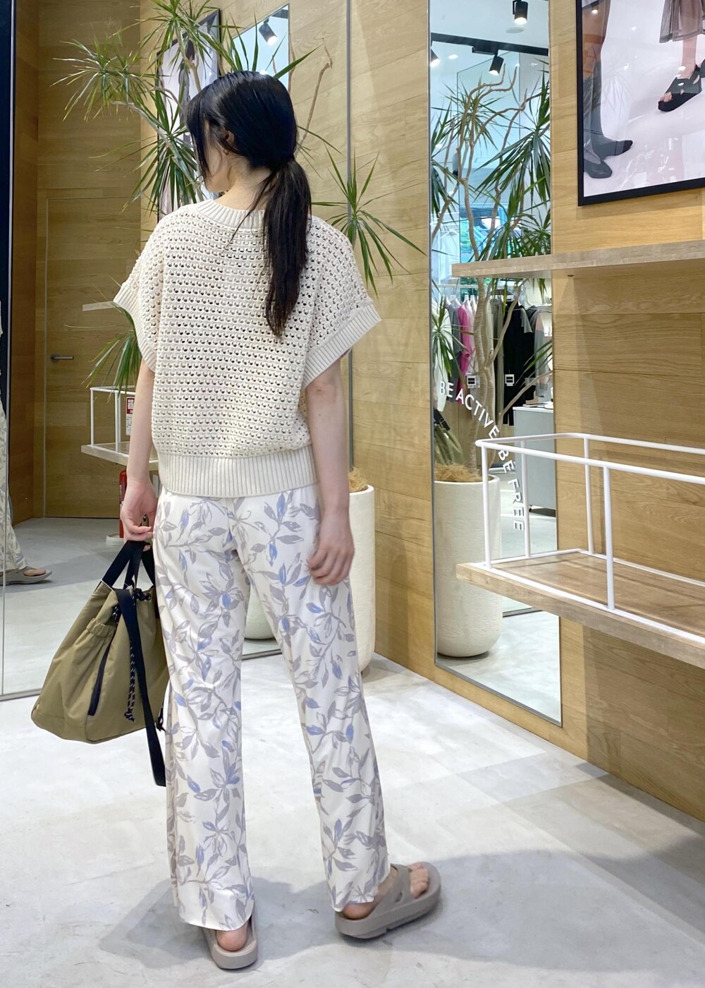 ベージュ系のその他パンツ、ベージュ系のサンダル、ホワイト系のニット/セーターを着用したレディースの夏コーディネートの4枚目の写真