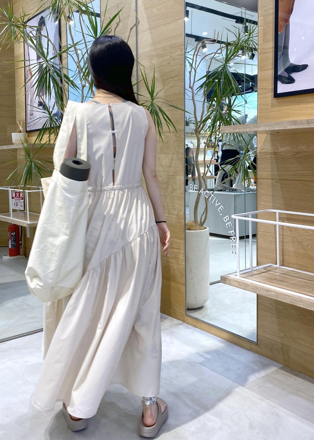 ベージュ系のサンダル、ホワイト系のトートバッグ、ホワイト系のワンピースを着用したレディースの夏コーディネートの3枚目の写真