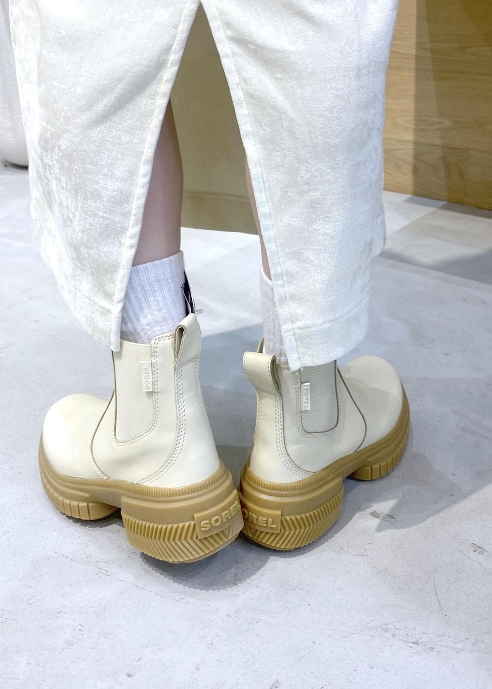 ホワイト系のショルダーバッグ、ホワイト系のブーツ、ホワイト系のパーカーを着用したレディースの冬コーディネートの9枚目の写真