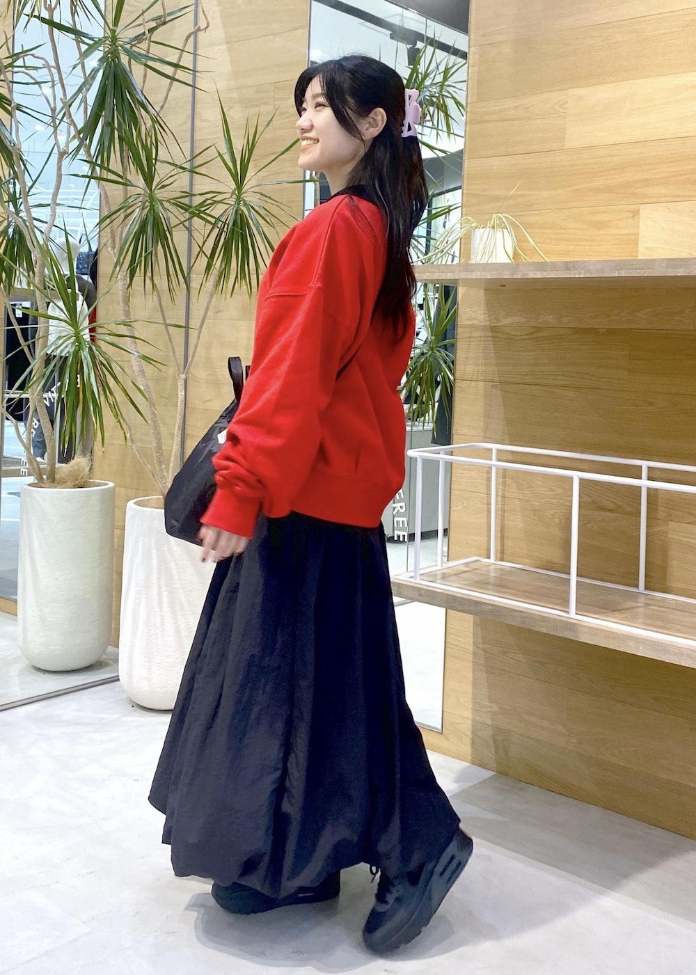 ブラック系のカーディガン/ボレロ、ブラック系のスニーカー、レッド系のスウェットを着用したレディースの冬コーディネートの4枚目の写真