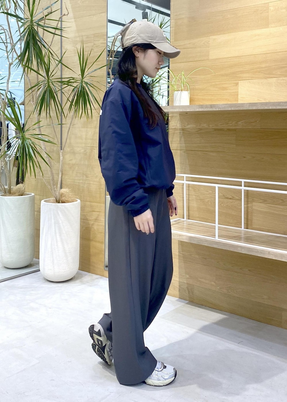 グレー系のスラックス、ホワイト系のスニーカー、ブルー系のその他トップスを着用したレディースの秋コーディネートの5枚目の写真