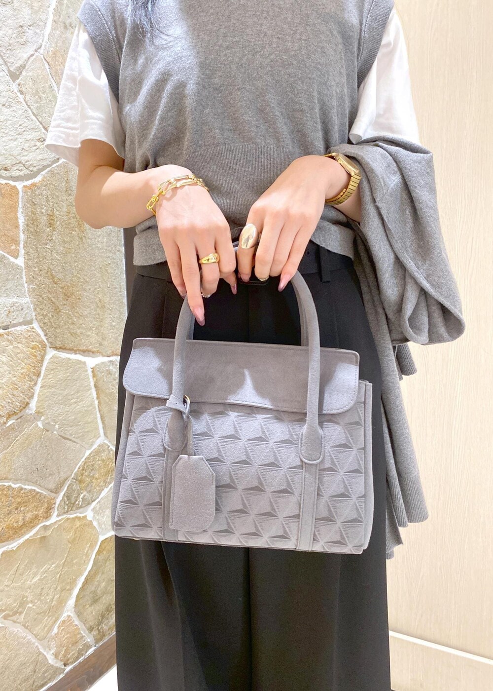 ブラック系のスニーカー、グレー系のニット/セーター、ブラック系のスラックスを着用したレディースの秋コーディネートの6枚目の写真