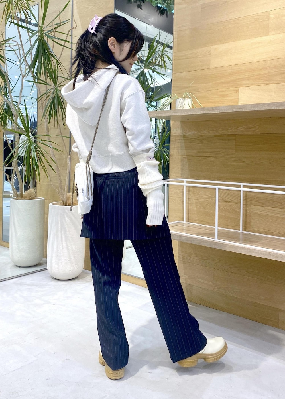 ホワイト系のショルダーバッグ、ホワイト系のブーツ、ホワイト系のパーカーを着用したレディースの冬コーディネートの5枚目の写真