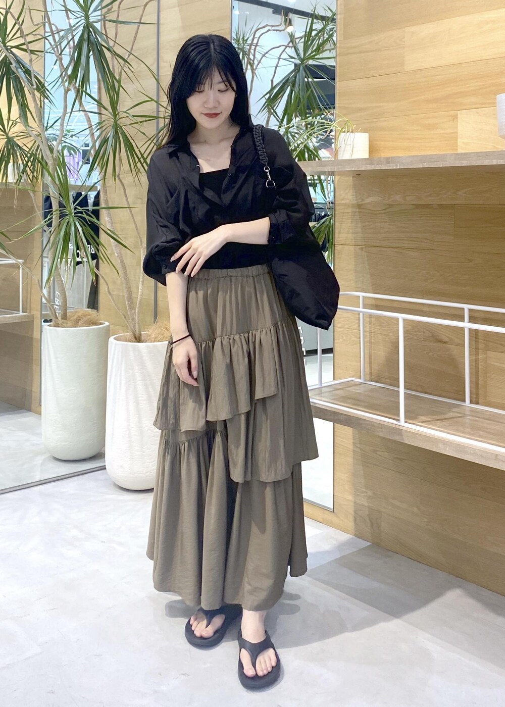グリーン系のスカート、ブラック系のキャミソール、ブラック系のサンダルを着用したレディースの夏コーディネートの2枚目の写真