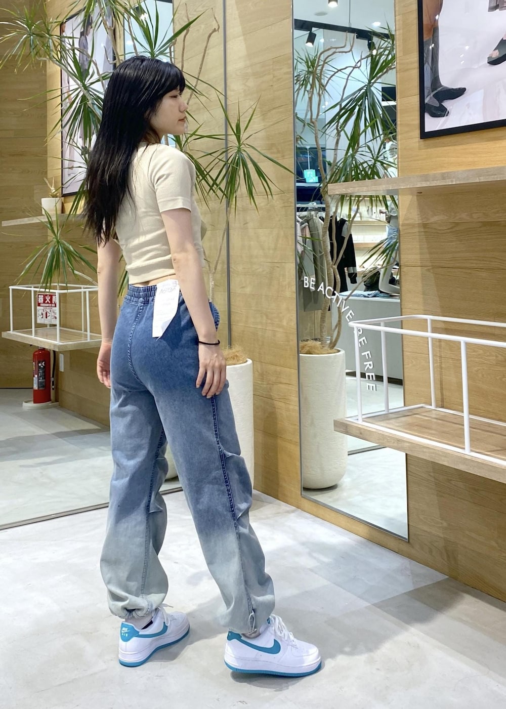 イエロー系のTシャツ/カットソー、イエロー系のボディバッグ/ウエストポーチ、ブルー系のデニムパンツを着用したレディースの夏コーディネートの3枚目の写真