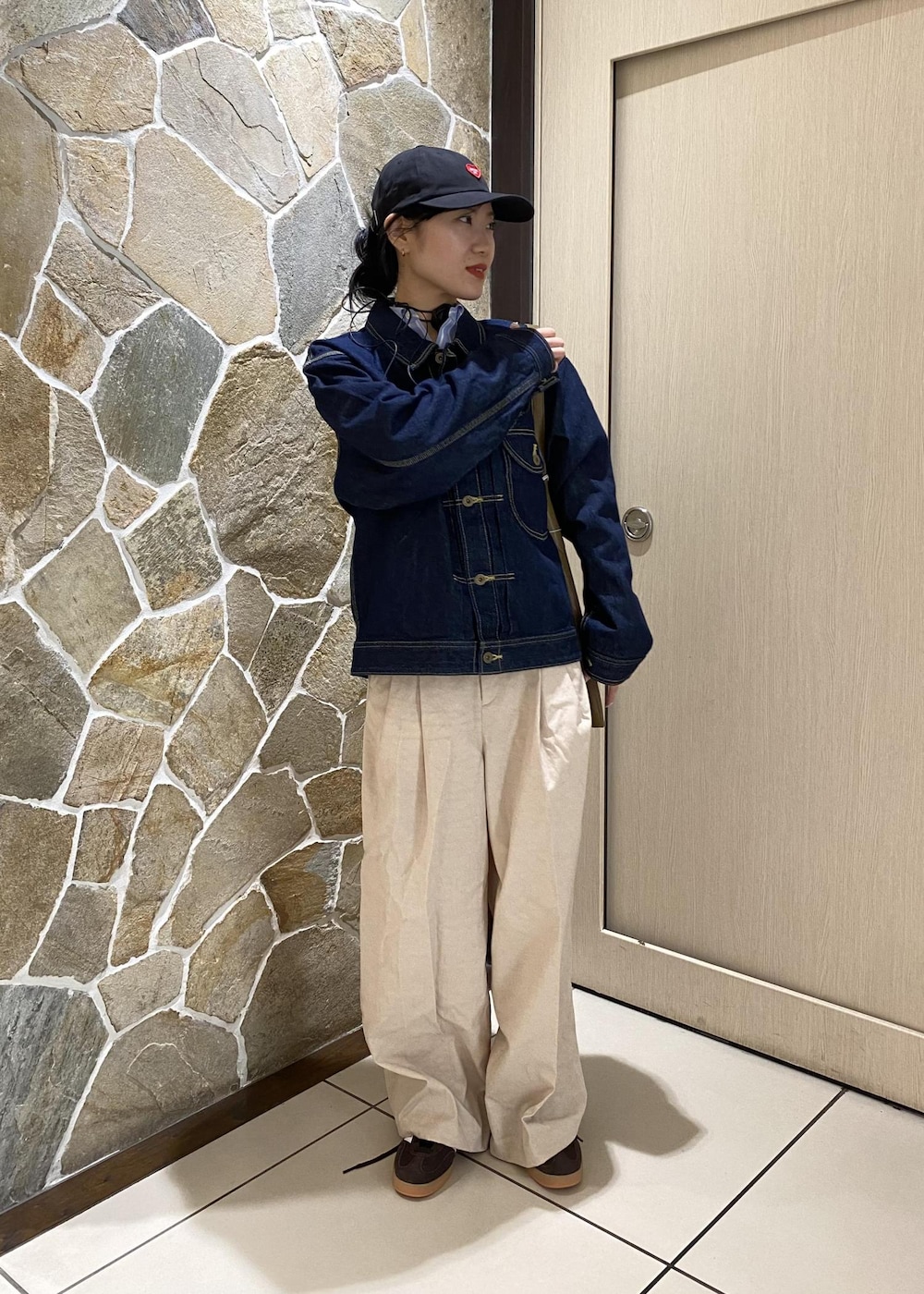 グリーン系のショルダーバッグ、ブルー系のデニムジャケット、ホワイト系のその他パンツを着用したレディースの冬コーディネートの4枚目の写真