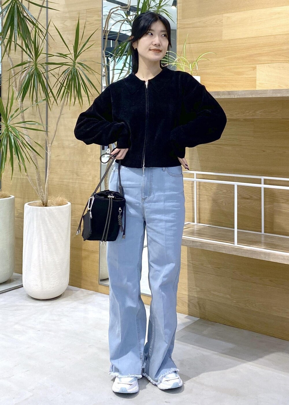 ブルー系のデニムパンツ、ブラック系のショルダーバッグ、ブラック系のカーディガン/ボレロを着用したレディースの秋コーディネートの6枚目の写真