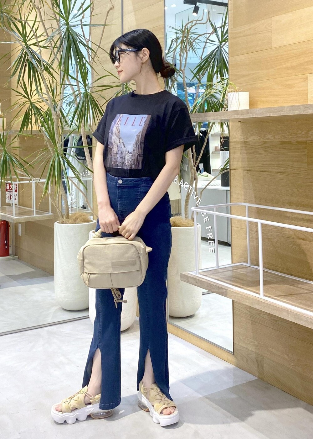 ブルー系のデニムパンツ、ベージュ系のサンダル、ブラック系のTシャツ/カットソーを着用したレディースの夏コーディネートの6枚目の写真