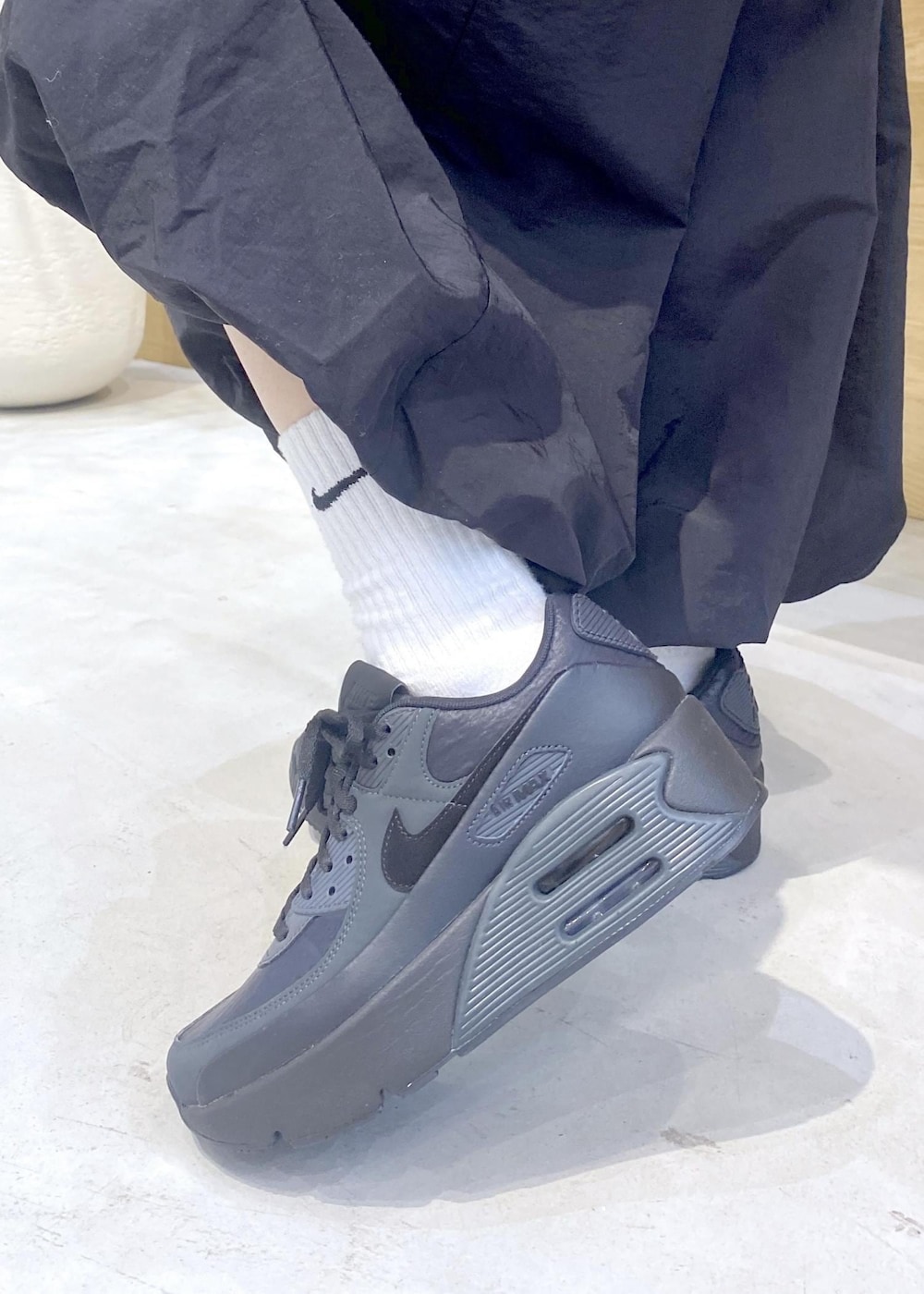 ブラック系のカーディガン/ボレロ、ブラック系のスニーカー、レッド系のスウェットを着用したレディースの冬コーディネートの8枚目の写真