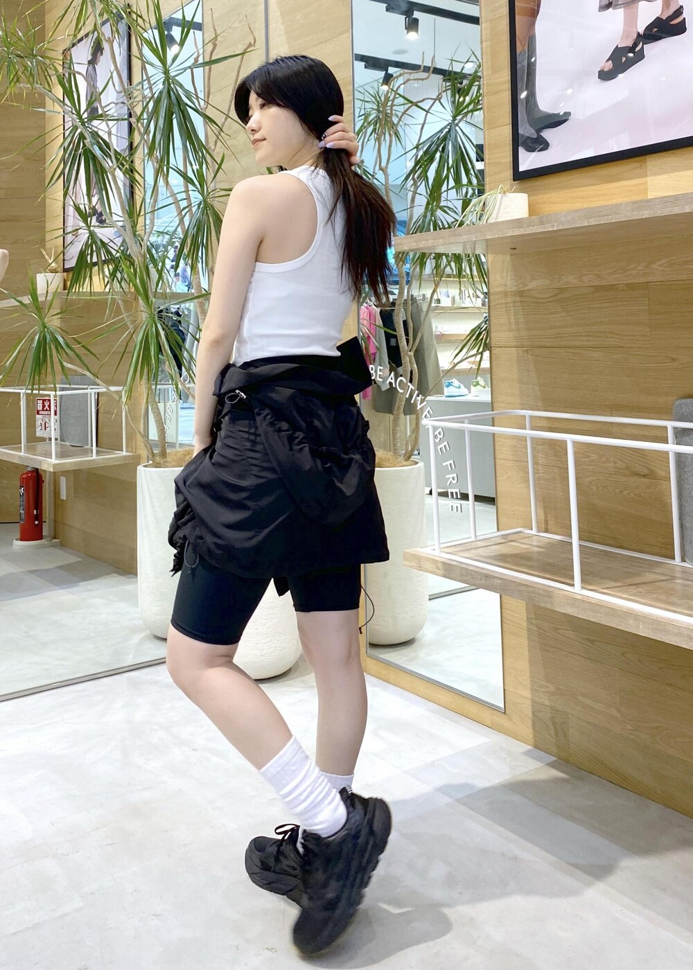 ブラック系のブルゾン、ホワイト系のタンクトップ、ブラック系のスニーカーを着用したレディースの夏コーディネートの7枚目の写真