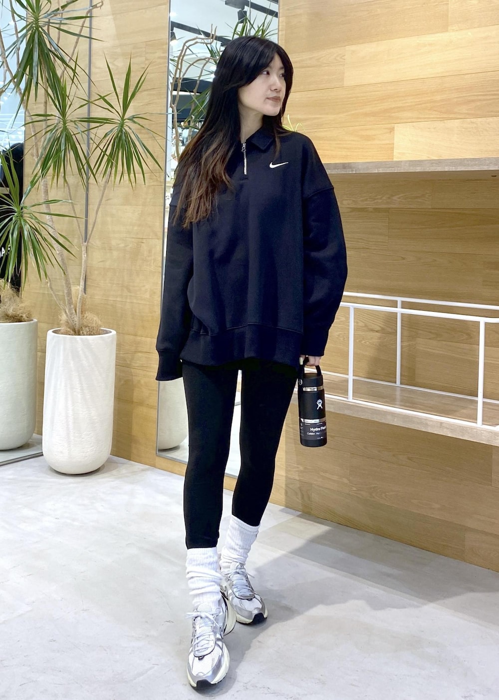 ホワイト系のスニーカー、ブラック系のスウェット、ブラック系のレギンス/スパッツを着用したレディースの秋コーディネートの3枚目の写真