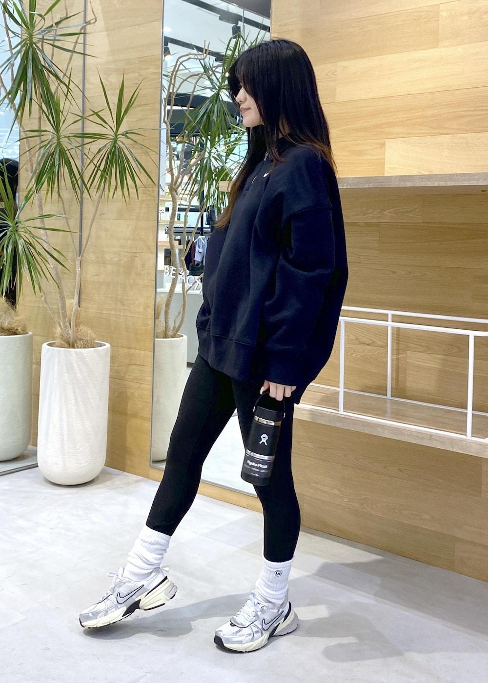 ホワイト系のスニーカー、ブラック系のスウェット、ブラック系のレギンス/スパッツを着用したレディースの秋コーディネートの6枚目の写真