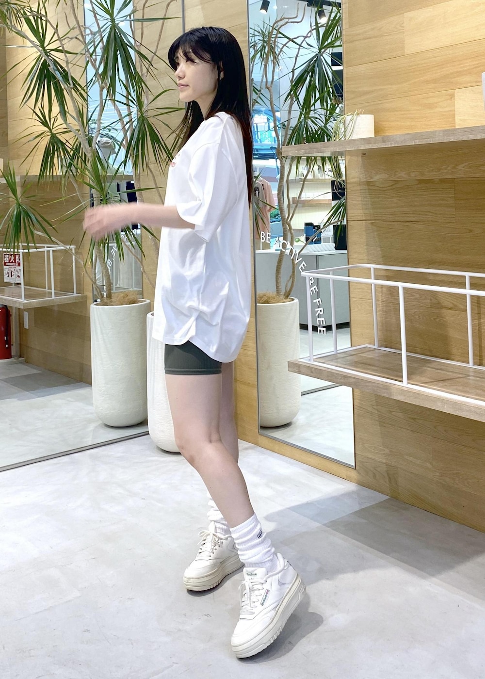 ホワイト系のスニーカー、ホワイト系のTシャツ/カットソー、グリーン系のレギンス/スパッツを着用したレディースの夏コーディネートの6枚目の写真