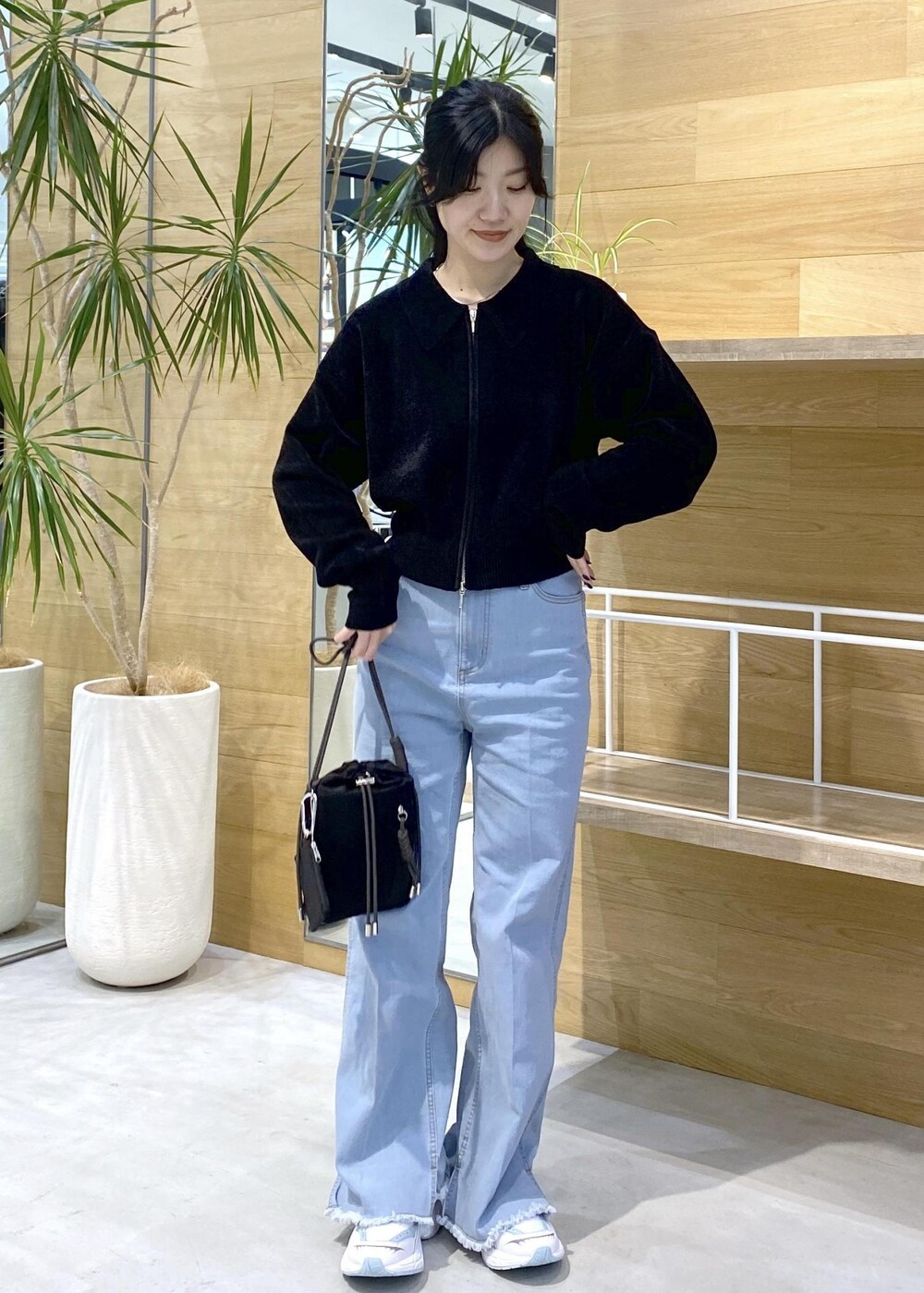 ブルー系のデニムパンツ、ブラック系のショルダーバッグ、ブラック系のカーディガン/ボレロを着用したレディースの秋コーディネートの7枚目の写真