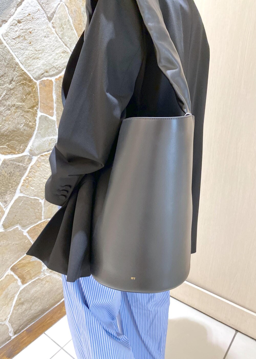 ブルー系のスラックス、ブラック系のテーラードジャケット、ブラック系のローファーを着用したレディースの秋コーディネートの7枚目の写真