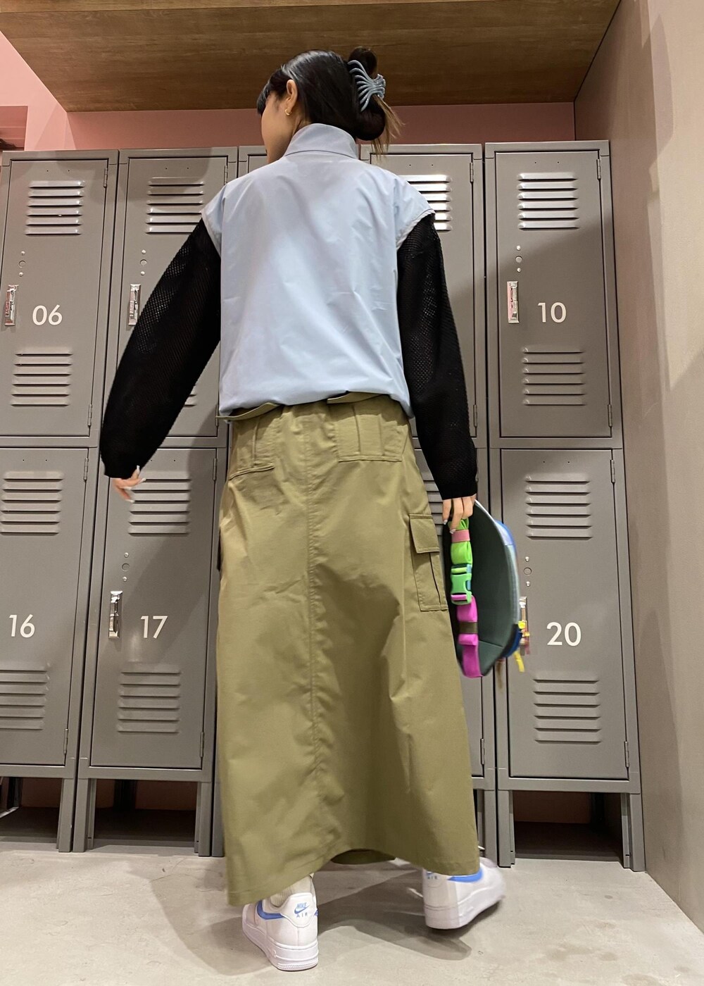 グリーン系のスカート、ブルー系のブルゾン、ブラック系のTシャツ/カットソーを着用したレディースの春コーディネートの3枚目の写真