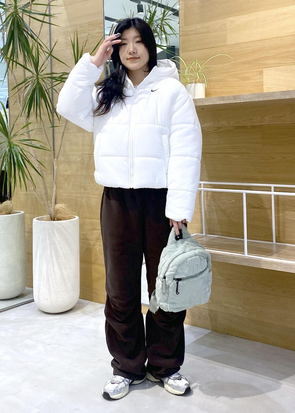 ブラウン系のその他パンツ、ホワイト系のスニーカー、ホワイト系のダウンジャケット/コートを着用したレディースの秋コーディネートの2枚目の写真