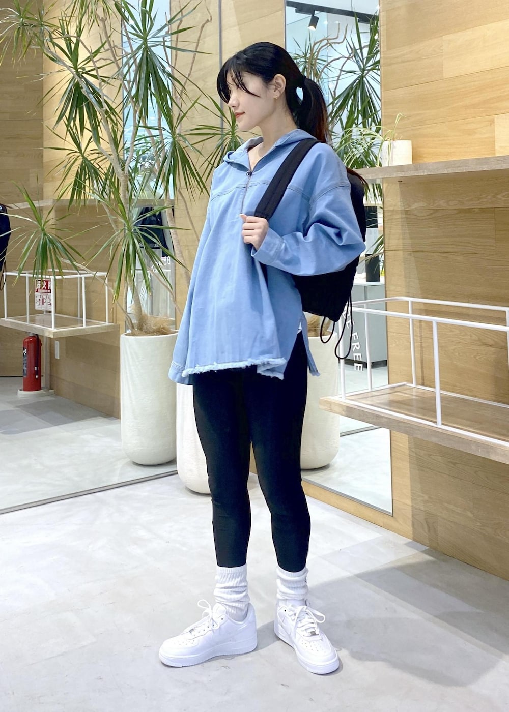 ホワイト系のスニーカー、ブルー系のパーカー、ブラック系のバックパック/リュックを着用したレディースの秋コーディネートの6枚目の写真