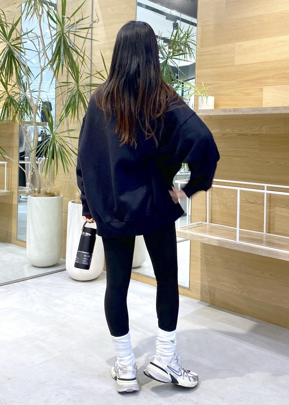 ホワイト系のスニーカー、ブラック系のスウェット、ブラック系のレギンス/スパッツを着用したレディースの秋コーディネートの5枚目の写真
