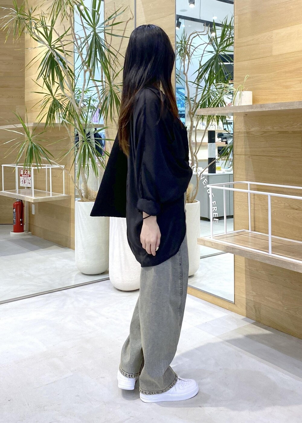 ホワイト系のスニーカー、ブラック系のキャミソール、ベージュ系のデニムパンツを着用したレディースの秋コーディネートの4枚目の写真