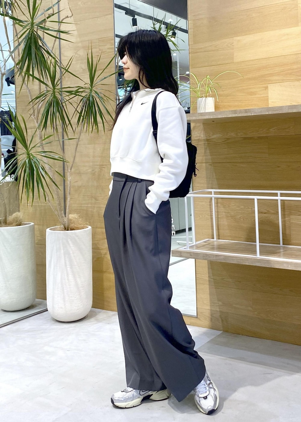 グレー系のスラックス、ホワイト系のスニーカーを着用したレディースの秋コーディネートの5枚目の写真