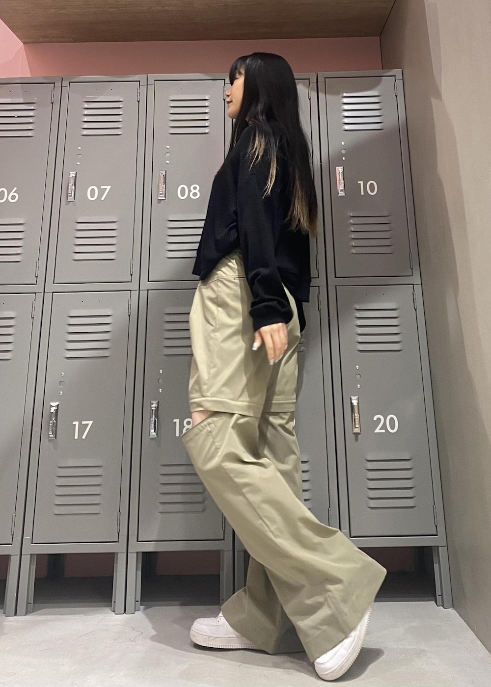 ホワイト系のスニーカー、ブラック系のパーカー、グリーン系のその他パンツを着用したレディースの春コーディネートの4枚目の写真