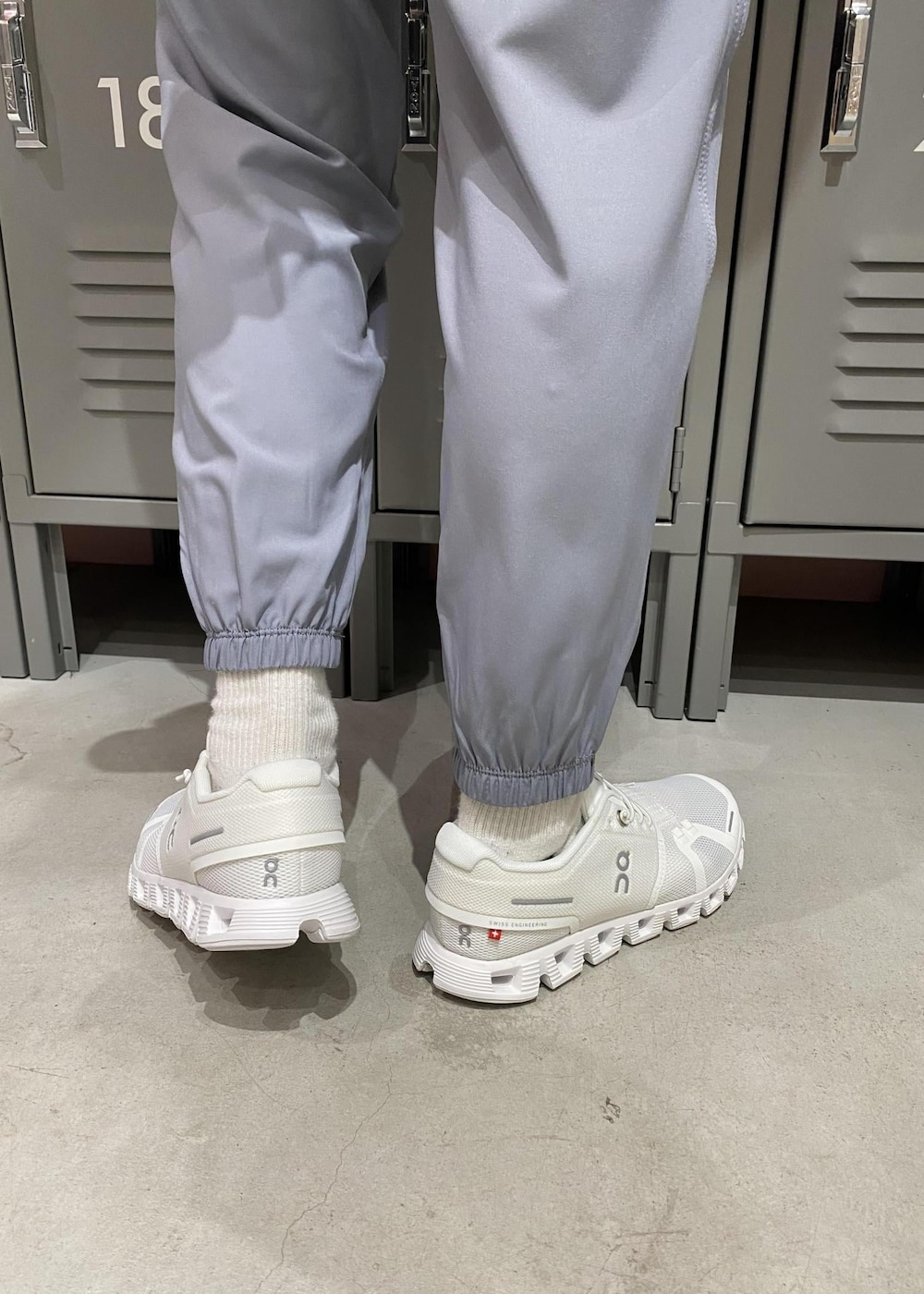 ホワイト系のスニーカー、ブラック系のブルゾン、ホワイト系のブラジャーを着用したレディースの春コーディネートの6枚目の写真