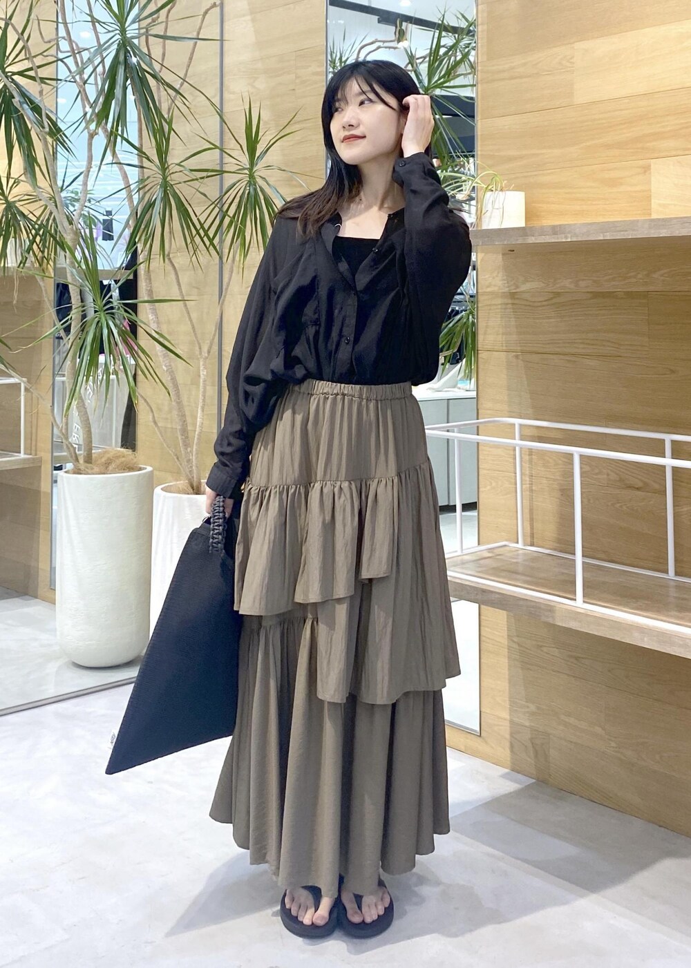 グリーン系のスカート、ブラック系のキャミソール、ブラック系のサンダルを着用したレディースの夏コーディネートの7枚目の写真