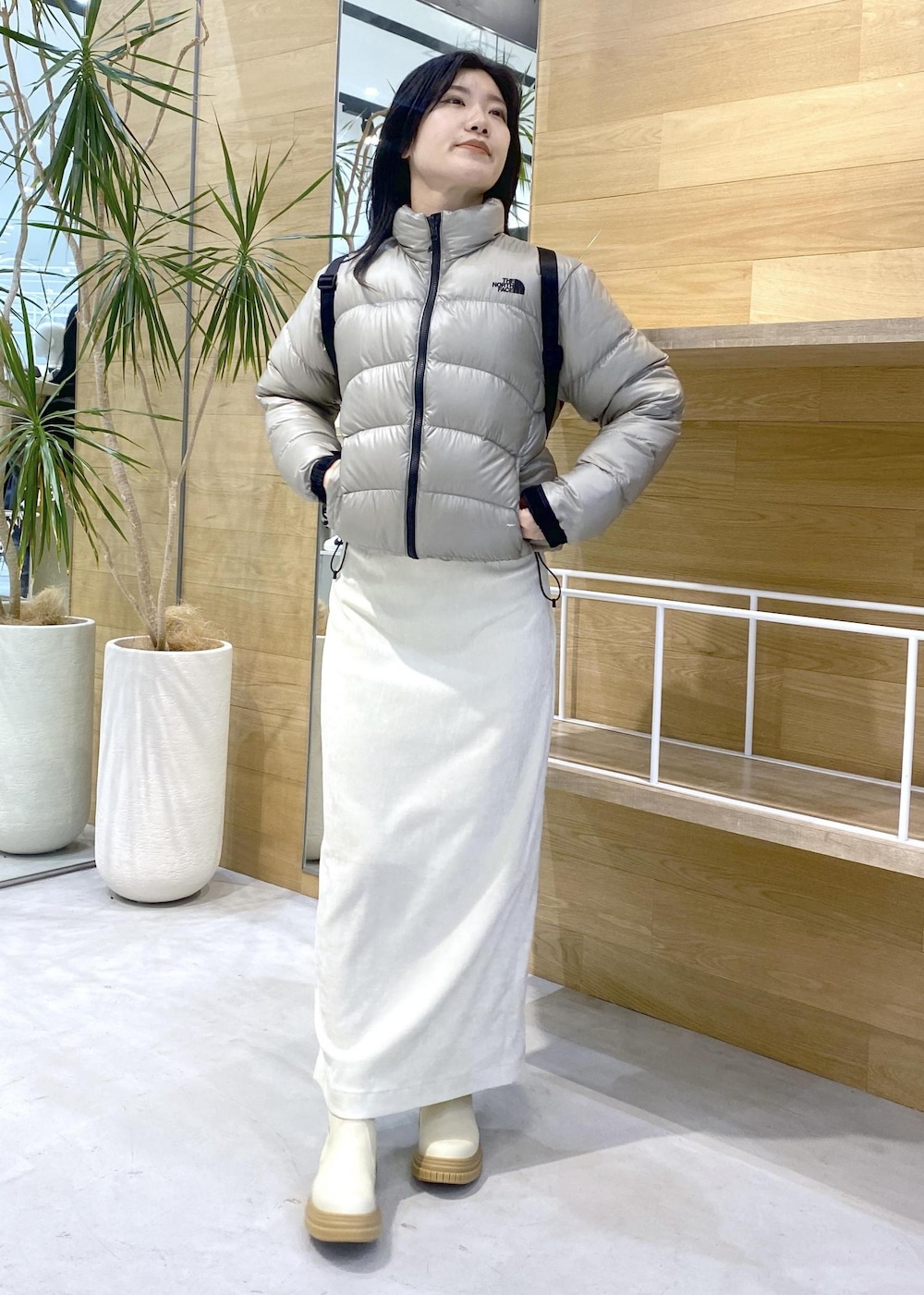 ベージュ系のダウンジャケット/コート、ホワイト系のブーツ、ホワイト系のスカートを着用したレディースの冬コーディネートの6枚目の写真