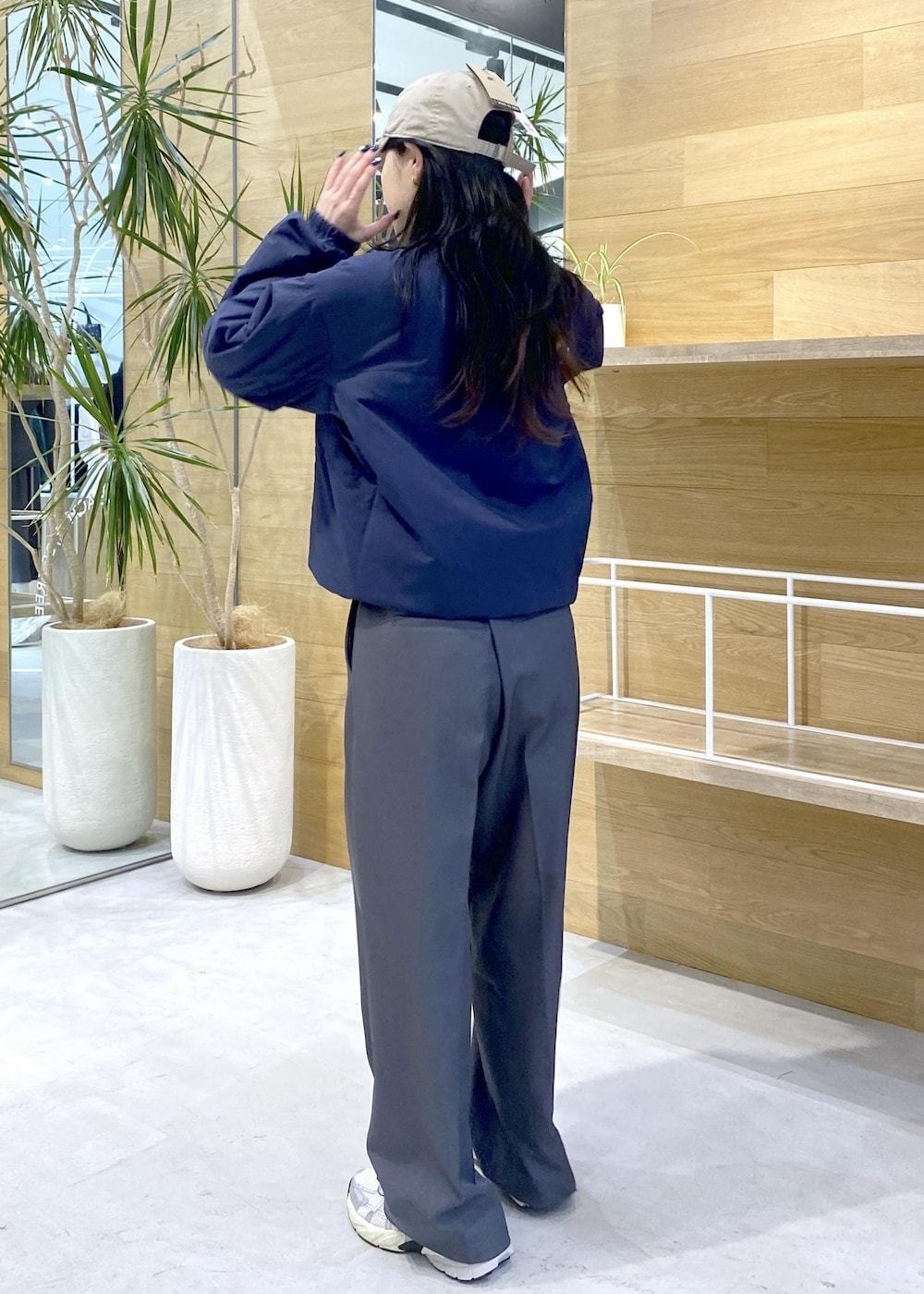 グレー系のスラックス、ホワイト系のスニーカー、ブルー系のその他トップスを着用したレディースの秋コーディネートの3枚目の写真