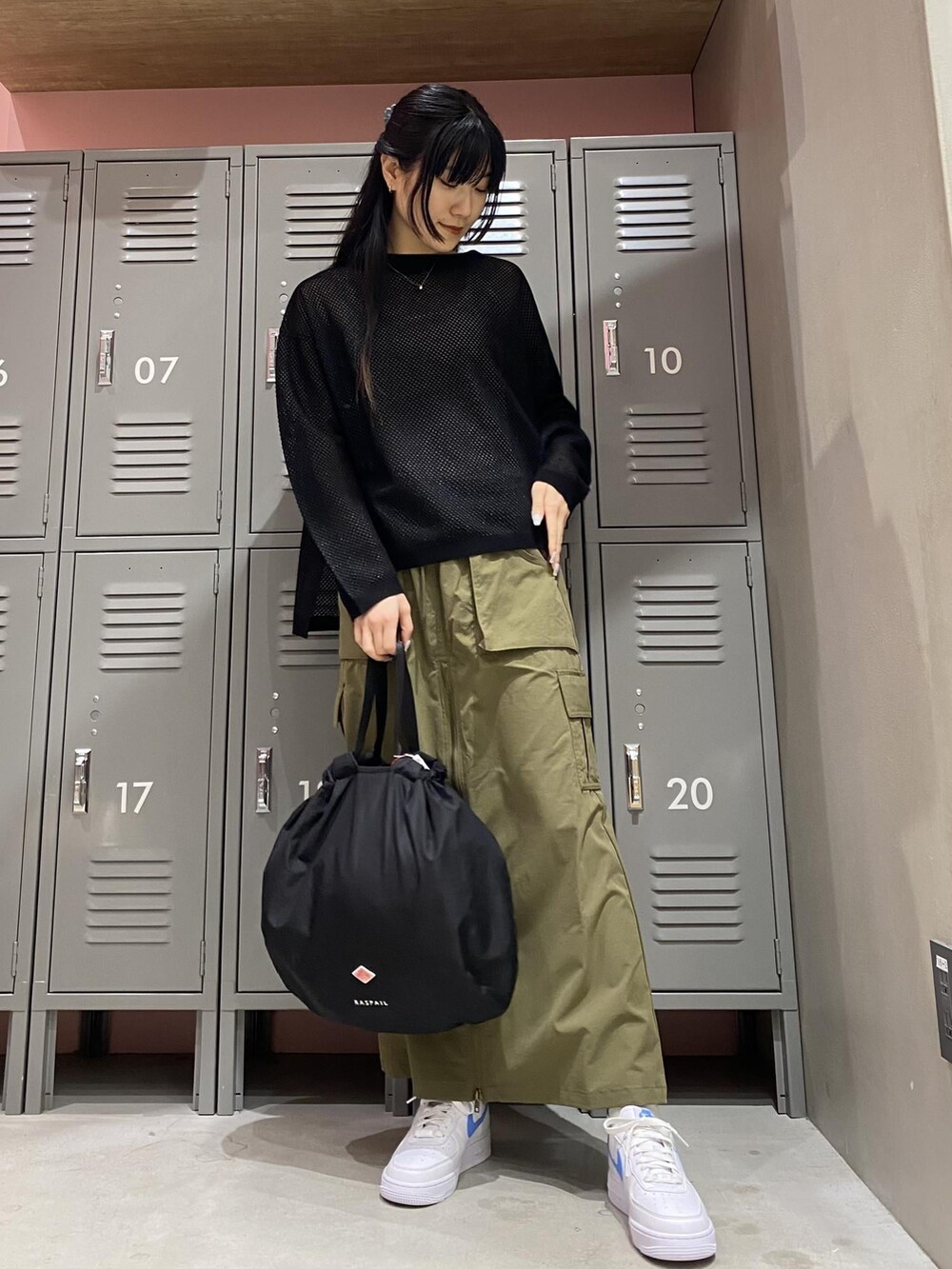 ホワイト系のスニーカー、ブラック系のハンドバッグ、ブラック系のTシャツ/カットソーを着用したレディースの春コーディネートの2枚目の写真