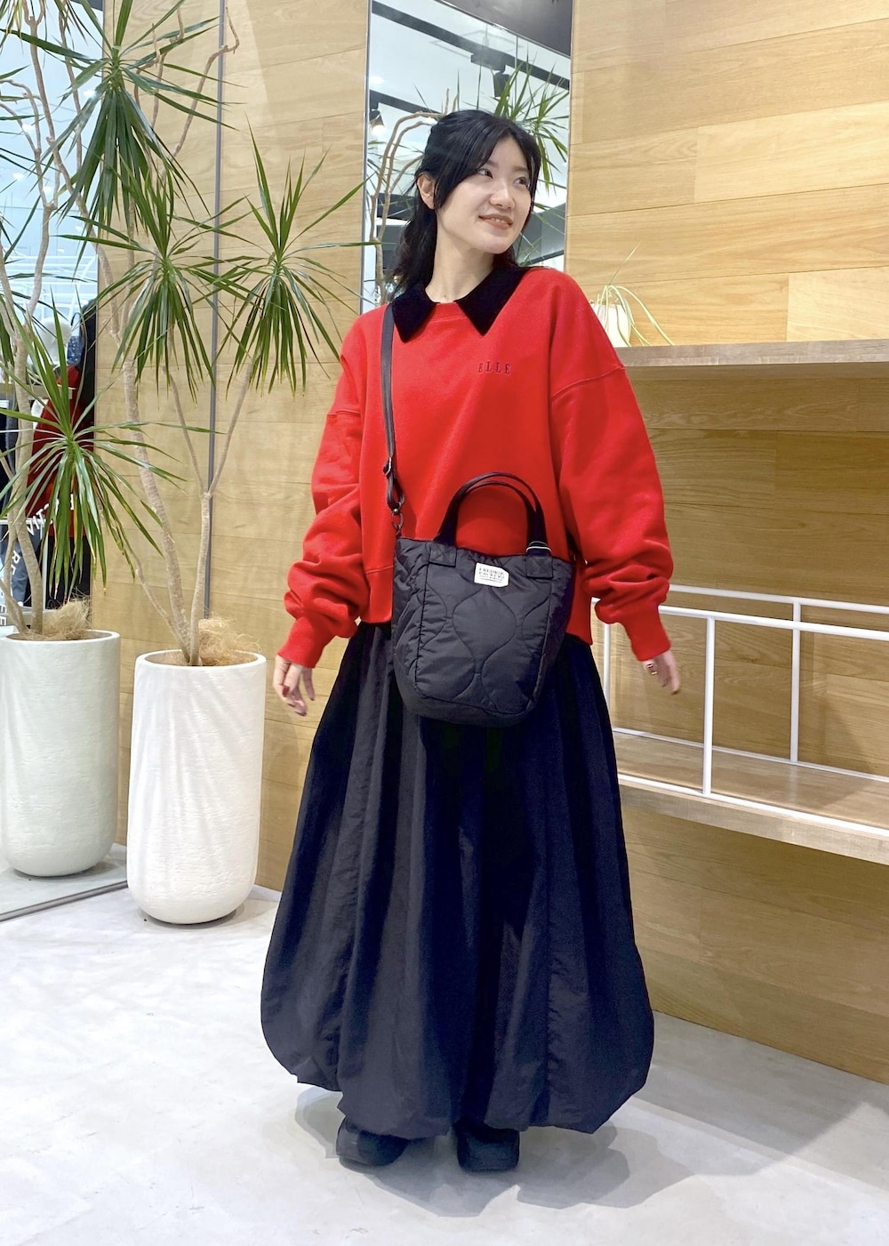 ブラック系のカーディガン/ボレロ、ブラック系のスニーカー、レッド系のスウェットを着用したレディースの冬コーディネートの7枚目の写真