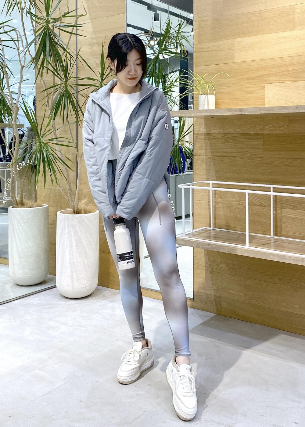 グリーン系のダウンジャケット/コート、ブルー系のレギンス/スパッツを着用したレディースの秋コーディネートの6枚目の写真