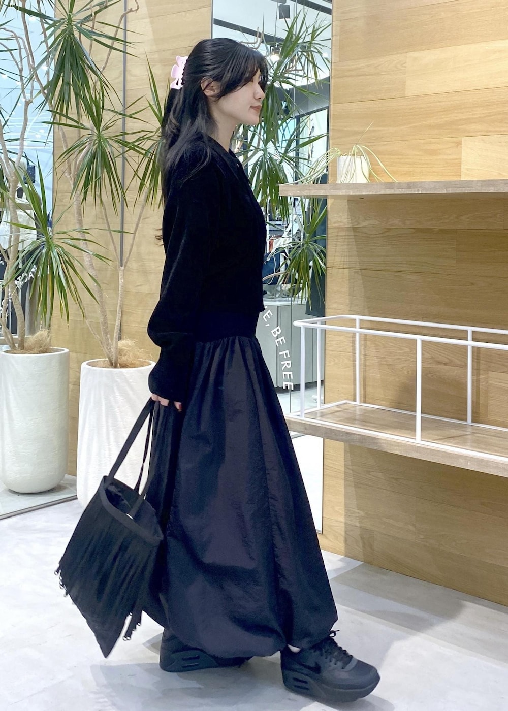 ブラック系のスカート、ブラック系のカーディガン/ボレロ、ブラック系のスニーカーを着用したレディースの冬コーディネートの4枚目の写真