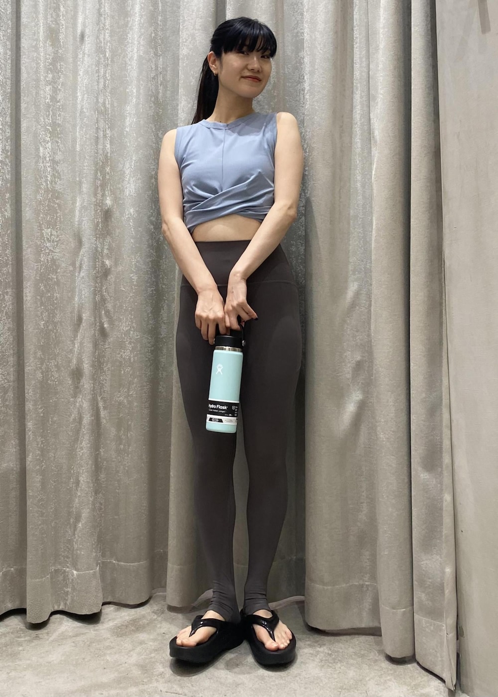 ブラック系のサンダル、ブルー系のタンクトップ、グリーン系のグラス/マグカップ/タンブラーを着用したレディースの春コーディネートの4枚目の写真