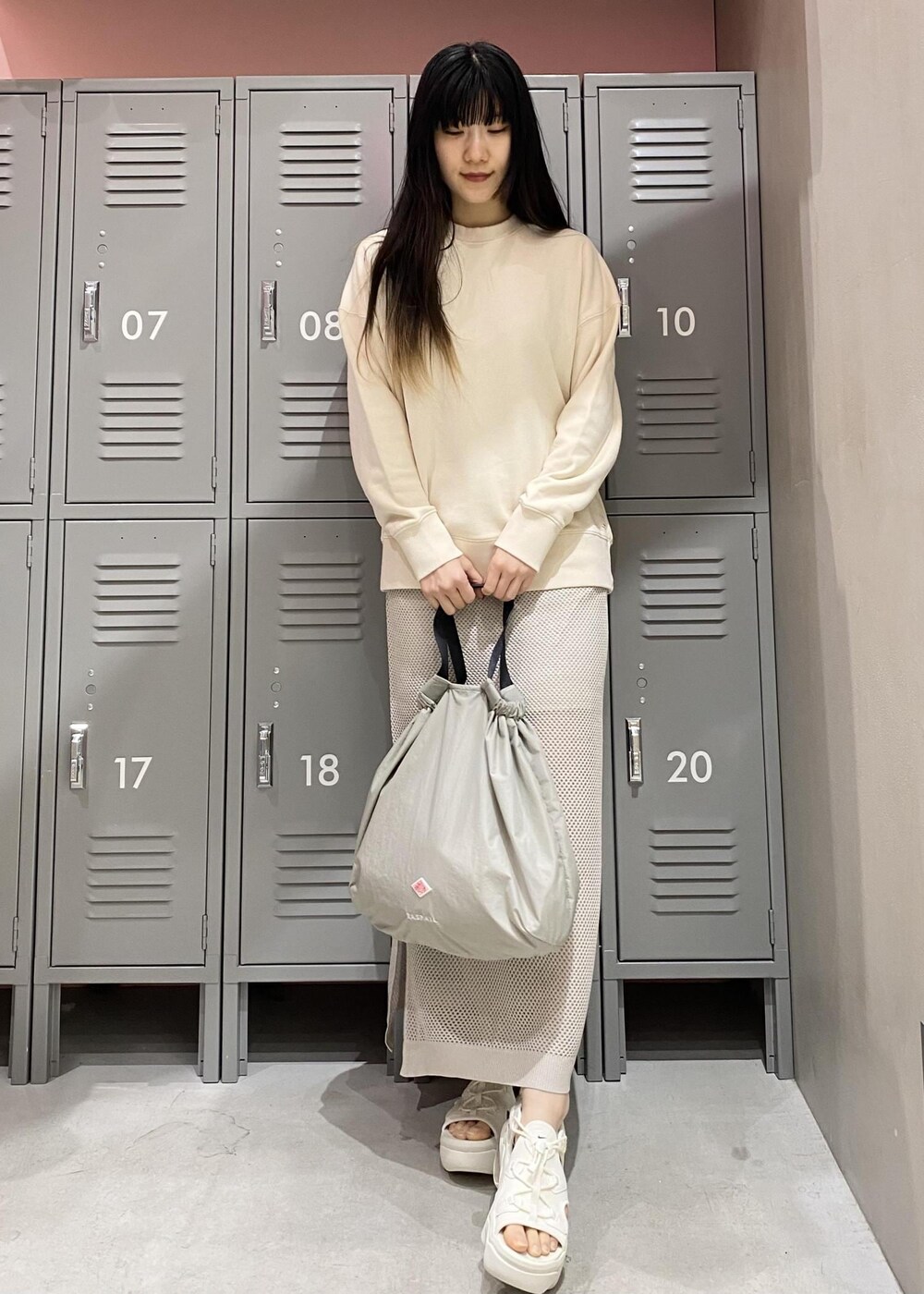 シルバー系のスカート、ホワイト系のサンダル、ベージュ系のスウェットを着用したレディースの春コーディネートの2枚目の写真
