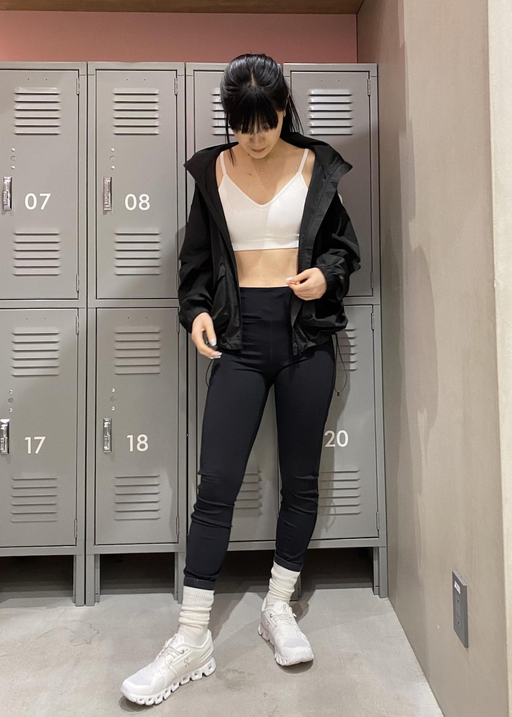 ホワイト系のスニーカー、ブラック系のブルゾン、ホワイト系のブラジャーを着用したレディースの春コーディネートの2枚目の写真