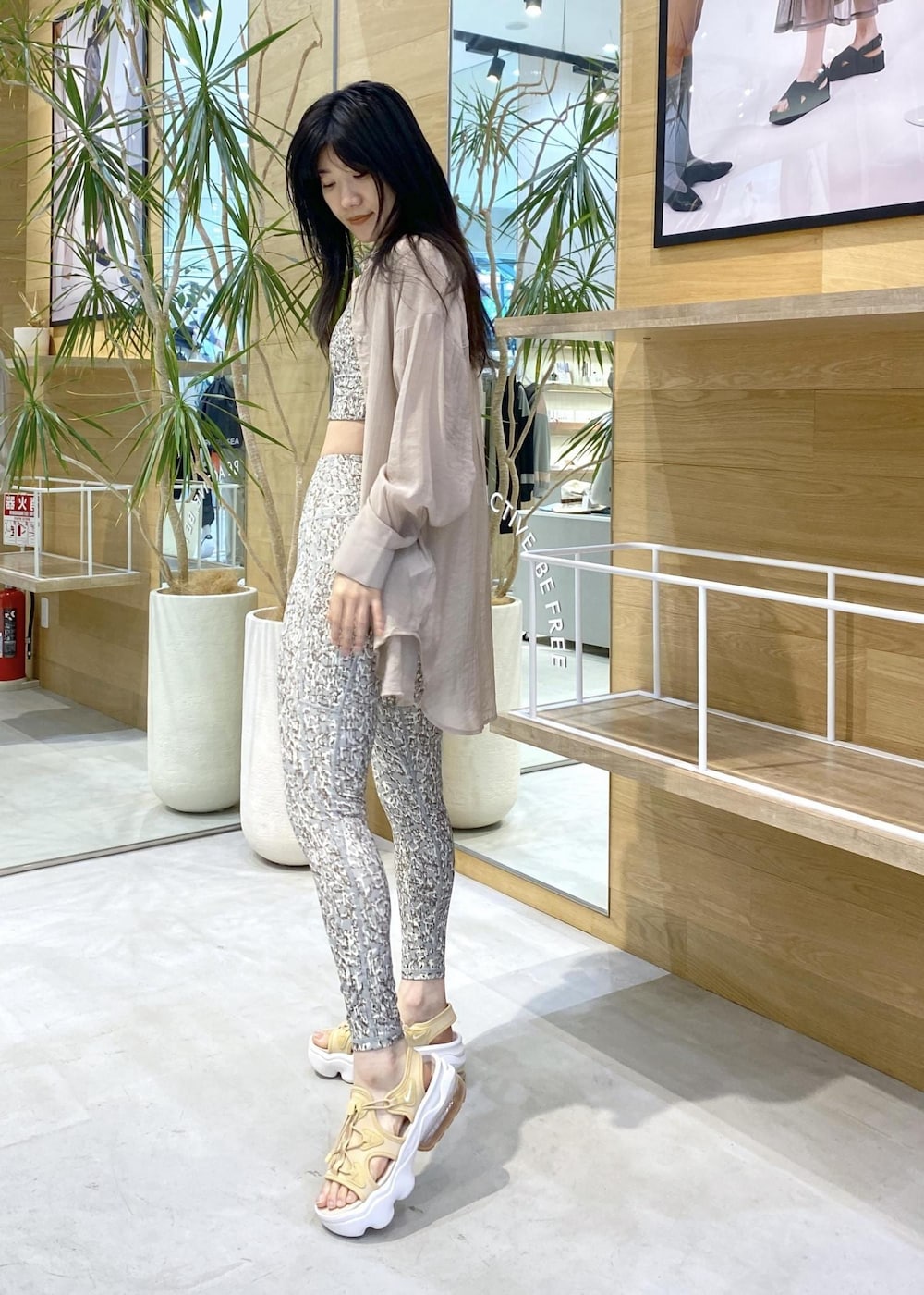 ベージュ系のサンダル、グリーン系のブラジャー、グリーン系のレギンス/スパッツを着用したレディースの夏コーディネートの2枚目の写真