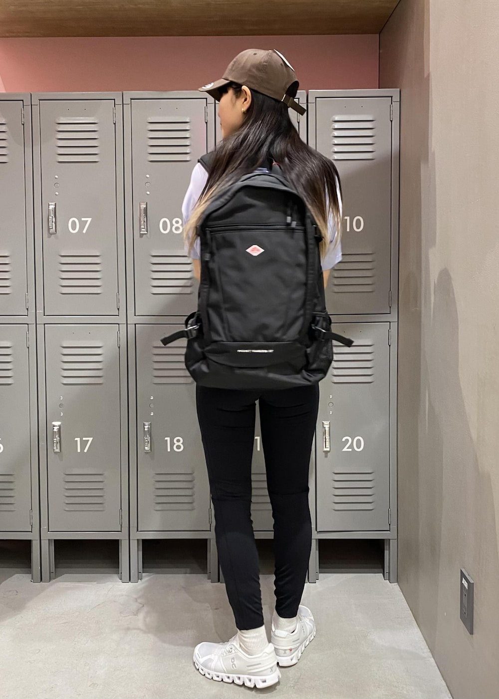 ブラック系のバックパック/リュック、ホワイト系のスニーカー、ブルー系のTシャツ/カットソーを着用したレディースの春コーディネートの2枚目の写真