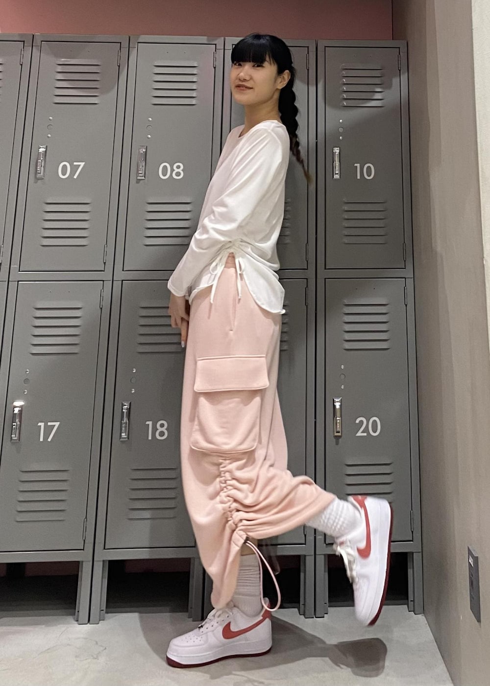 ピンク系のスカート、ホワイト系のTシャツ/カットソー、ホワイト系のスニーカーを着用したレディースの冬コーディネートの4枚目の写真