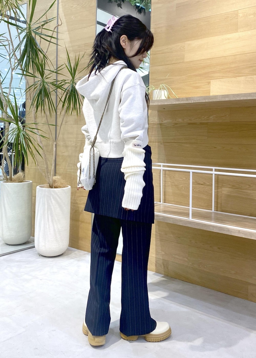 ホワイト系のショルダーバッグ、ホワイト系のブーツ、ホワイト系のパーカーを着用したレディースの冬コーディネートの7枚目の写真