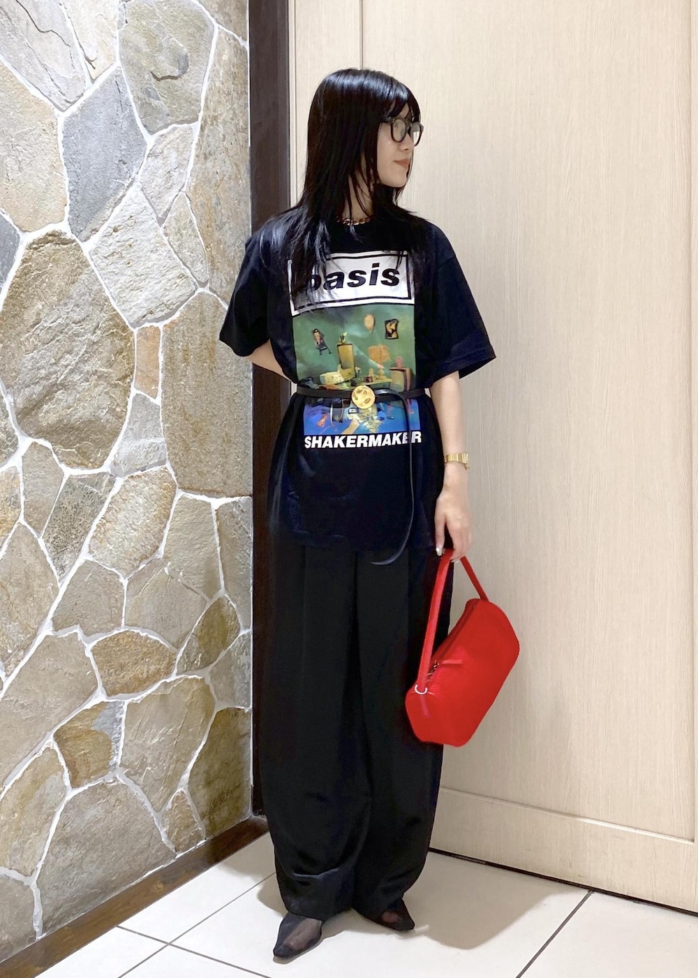 ブラック系のパンプス、ブラック系のスラックス、レッド系のハンドバッグを着用したレディースの夏コーディネートの3枚目の写真