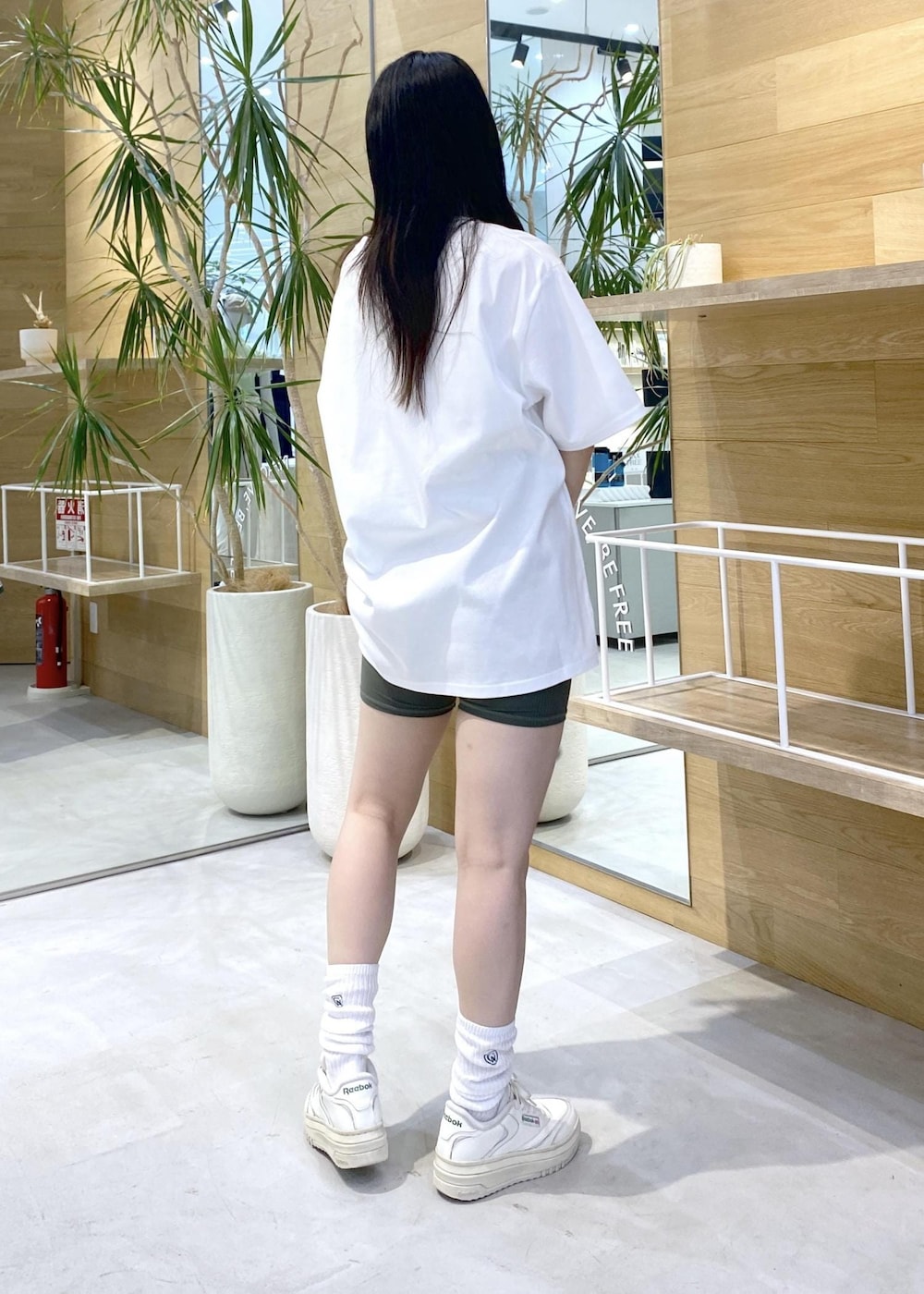 ホワイト系のスニーカー、ホワイト系のTシャツ/カットソー、グリーン系のレギンス/スパッツを着用したレディースの夏コーディネートの3枚目の写真
