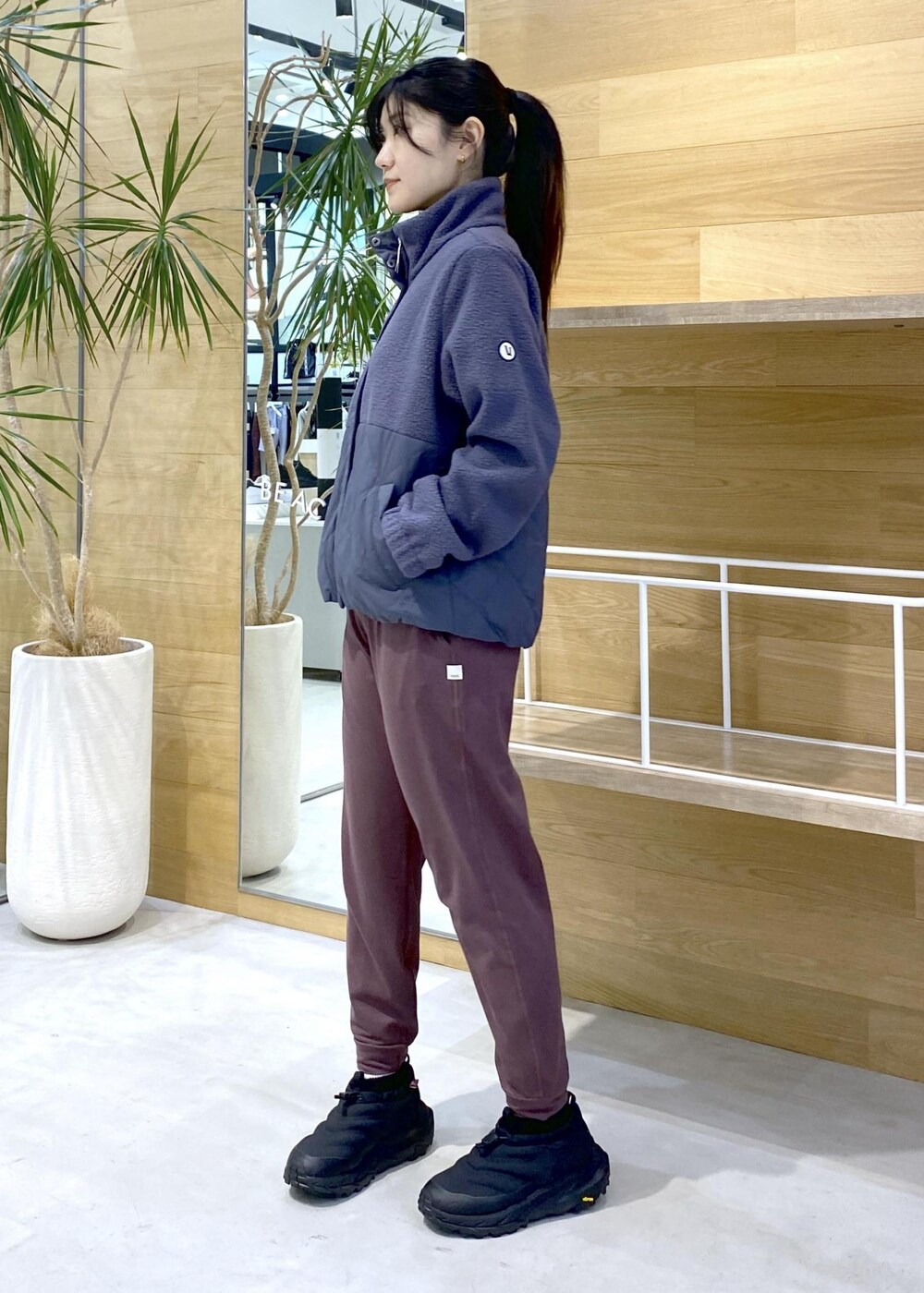 ブラック系のスニーカー、ブルー系のその他アウター、ピンク系のスラックスを着用したレディースの秋コーディネートの3枚目の写真