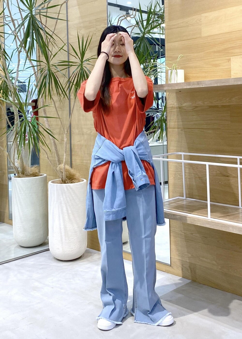 ホワイト系のスニーカー、ブルー系のパーカー、ブルー系のデニムパンツを着用したレディースの秋コーディネートの7枚目の写真