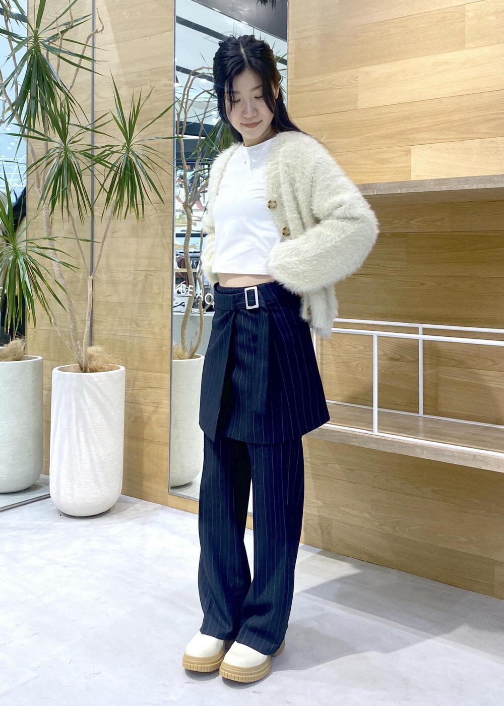 ホワイト系のカーディガン/ボレロ、ホワイト系のTシャツ/カットソー、ブルー系のその他パンツを着用したレディースの冬コーディネートの7枚目の写真