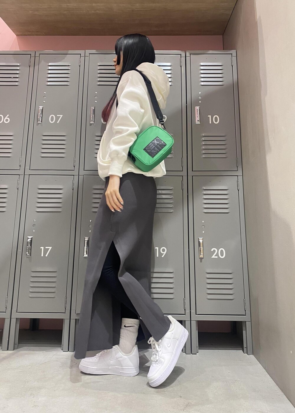 ホワイト系のパーカー、ホワイト系のスニーカー、ブラック系のワンピースを着用したレディースの冬コーディネートの2枚目の写真