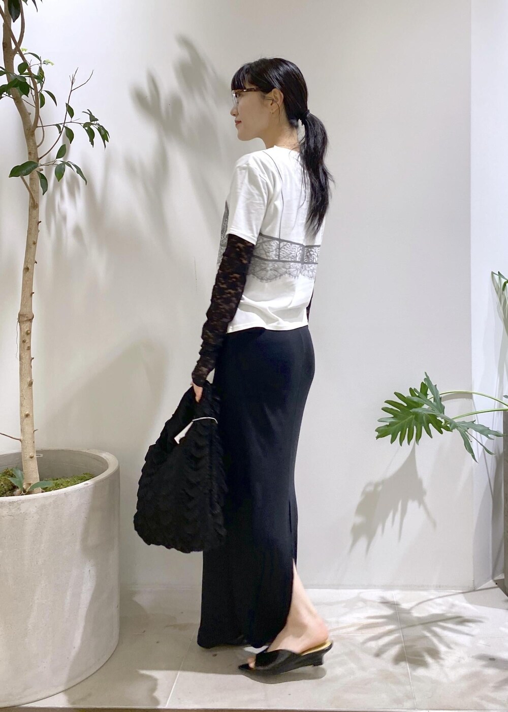 ブラック系のハンドバッグ、ブラック系のサンダル、ブラック系のスカートを着用したレディースの夏コーディネートの4枚目の写真